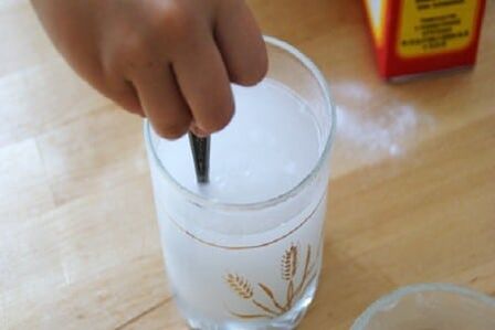 Bir stakan ichida eritilgan soda